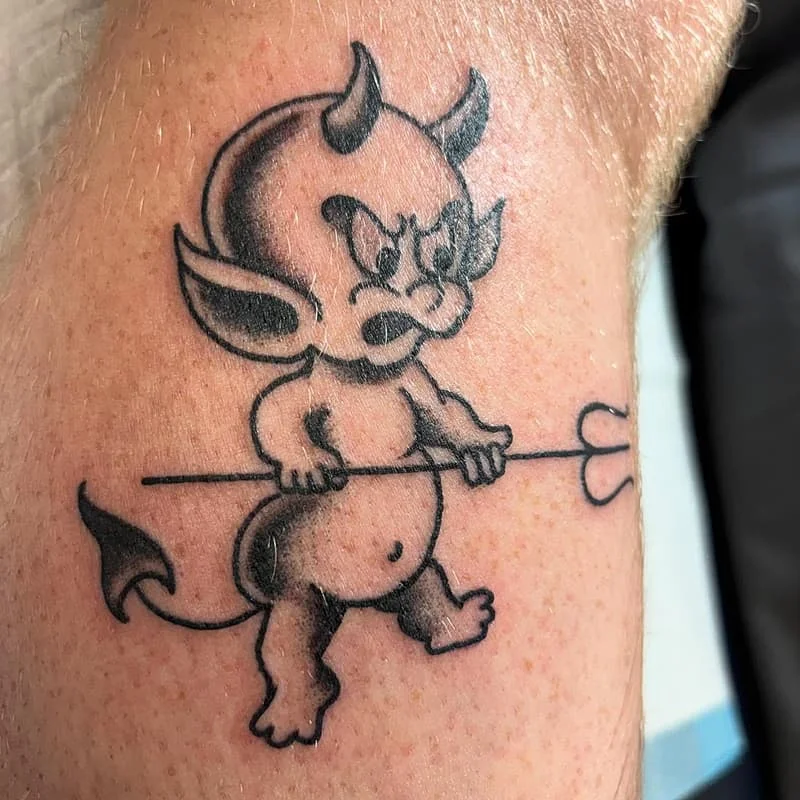 Angry cartoon devil tattoo on calf.