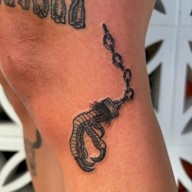 Illustrative octopus and chain tattoo on leg.